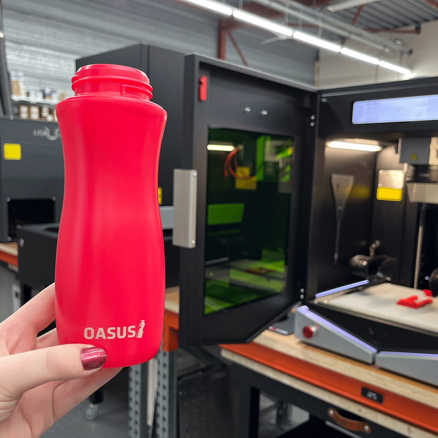 Laser engraving on a red Oasus water bottle