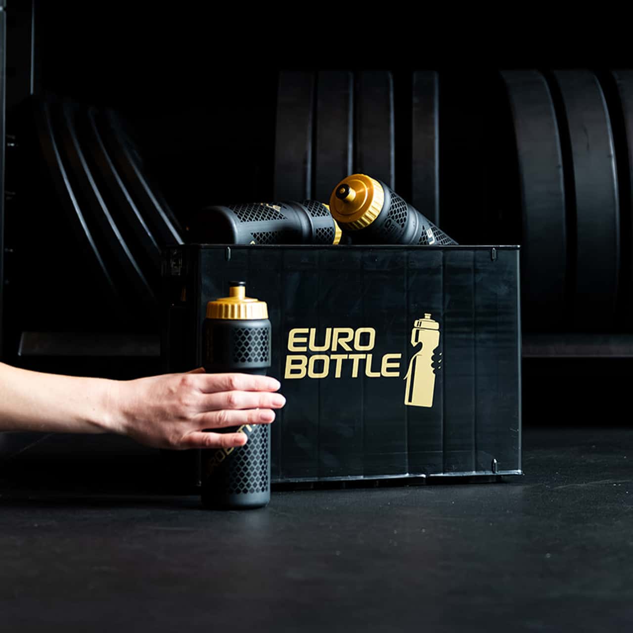 Eurobottle sportbidons in een krat in een fitnessruimte met gewichten