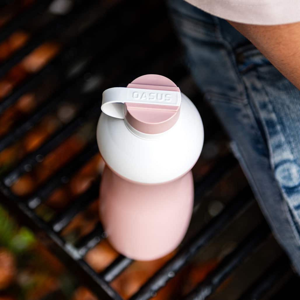 Detail einer rosa Oasus-Wasserflasche mit weißem festem Deckel und Gravur, biobasiertes und recycelbares Design