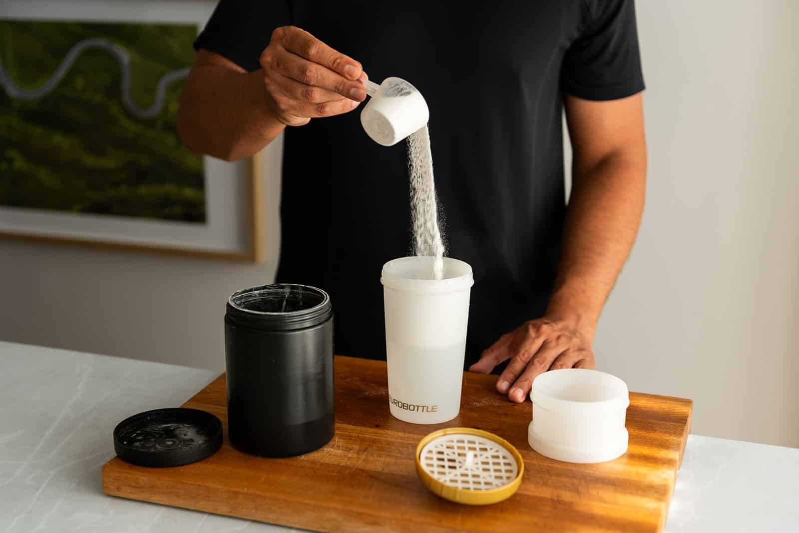 Boy pours powder into a shaker with a logo