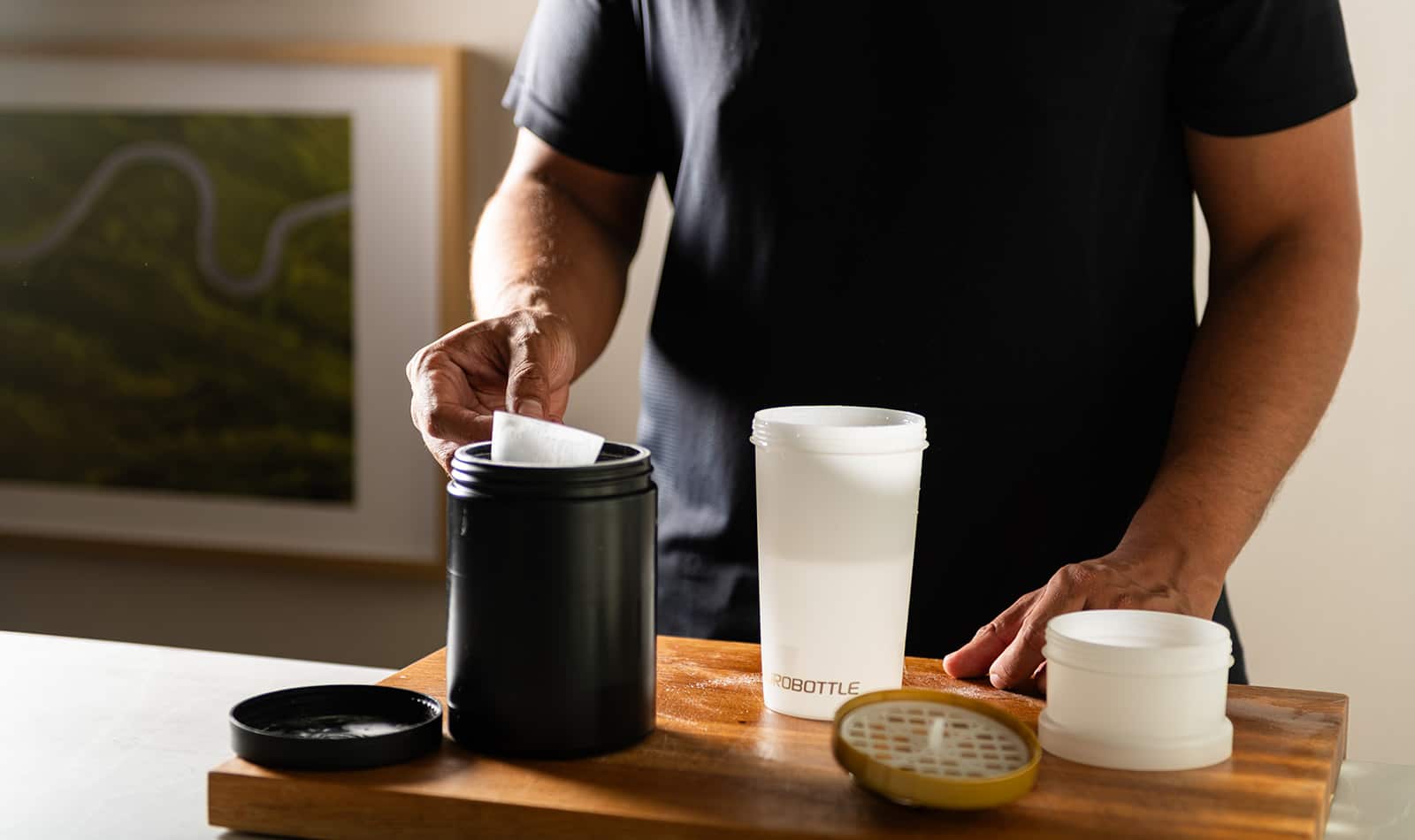 Zwarte en witte Eurobottle mesh-shaker van 550 ml op een tafel naast een sporttas